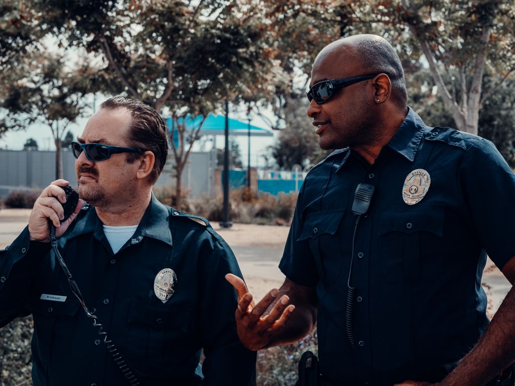 Two police officers conversing and coordinating in an outdoor setting, showcasing teamwork in law enforcement.